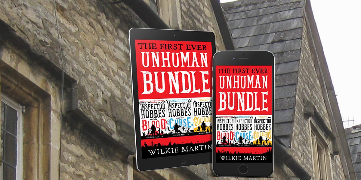 Kindle and phone showing cover of First Ever Unhuman Bundle with roof of Cotswold buildings behind